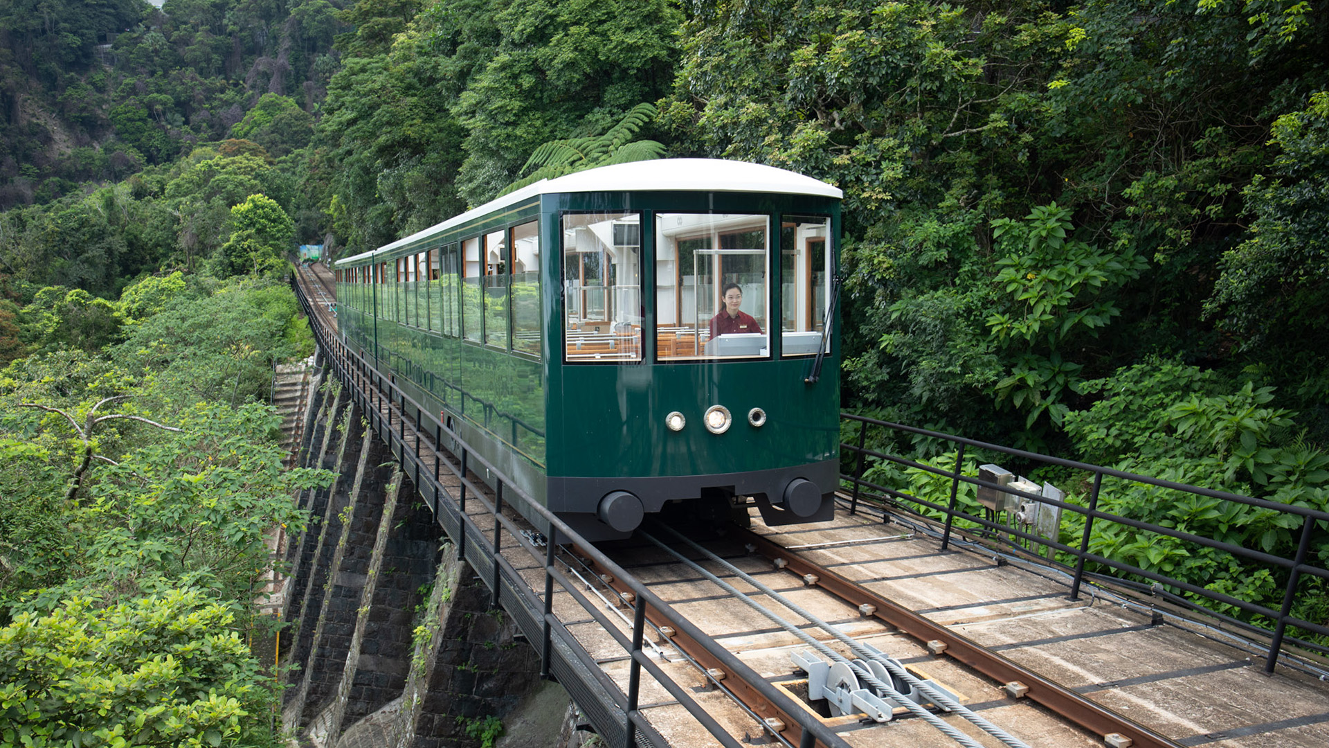 Đoàn tàu điện Peak Tram màu xanh lục cổ điển leo sườn dốc lên đỉnh Thái Bình Hong Kong
