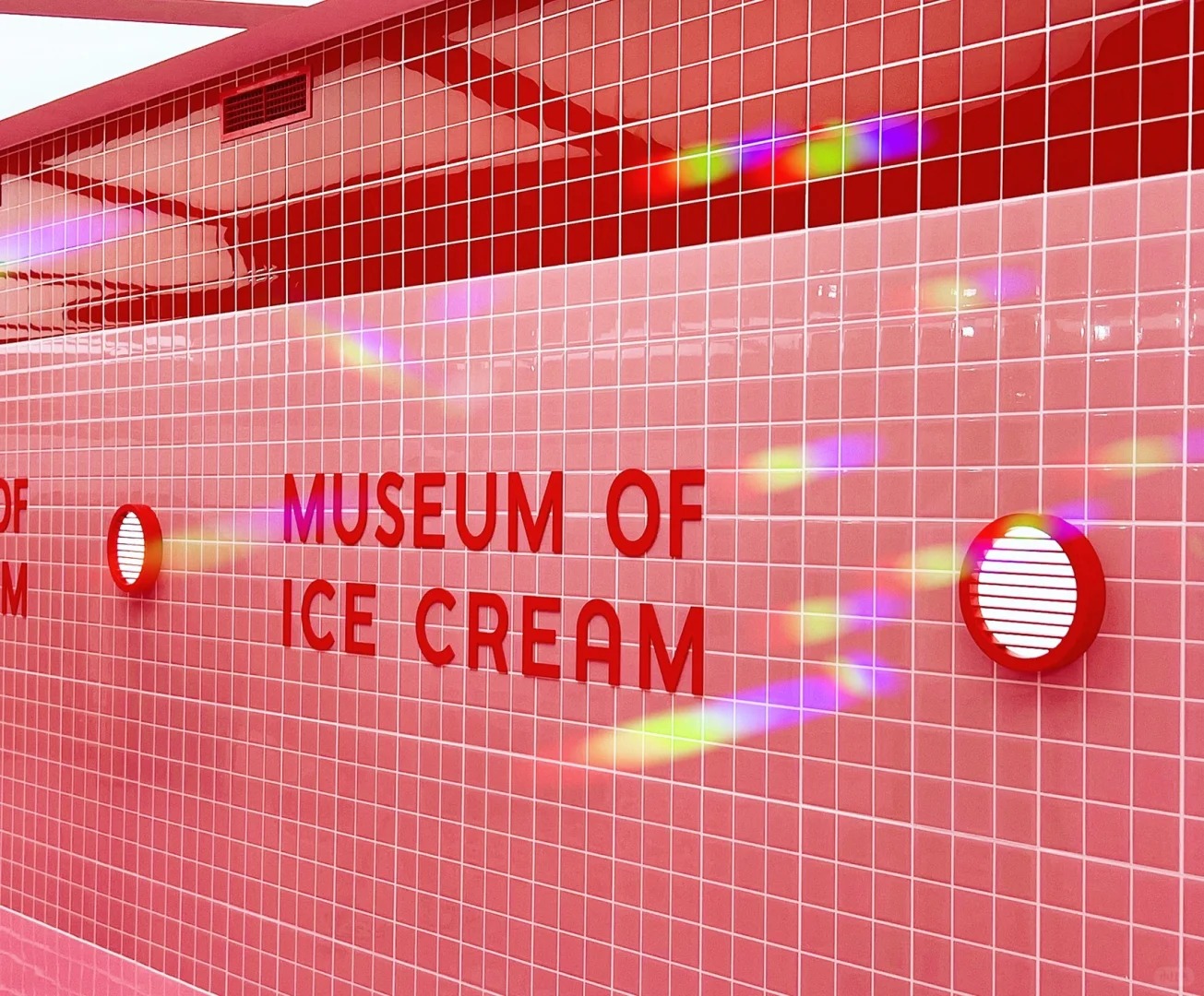 Phòng kem cầu vồng với tường phủ màu pastel và đèn LED hình kem.