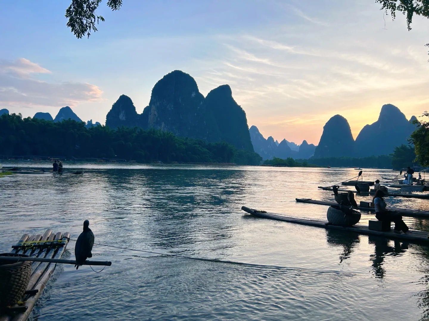 Khung cảnh núi sông hữu tình với bè tre chiều hoàng hôn