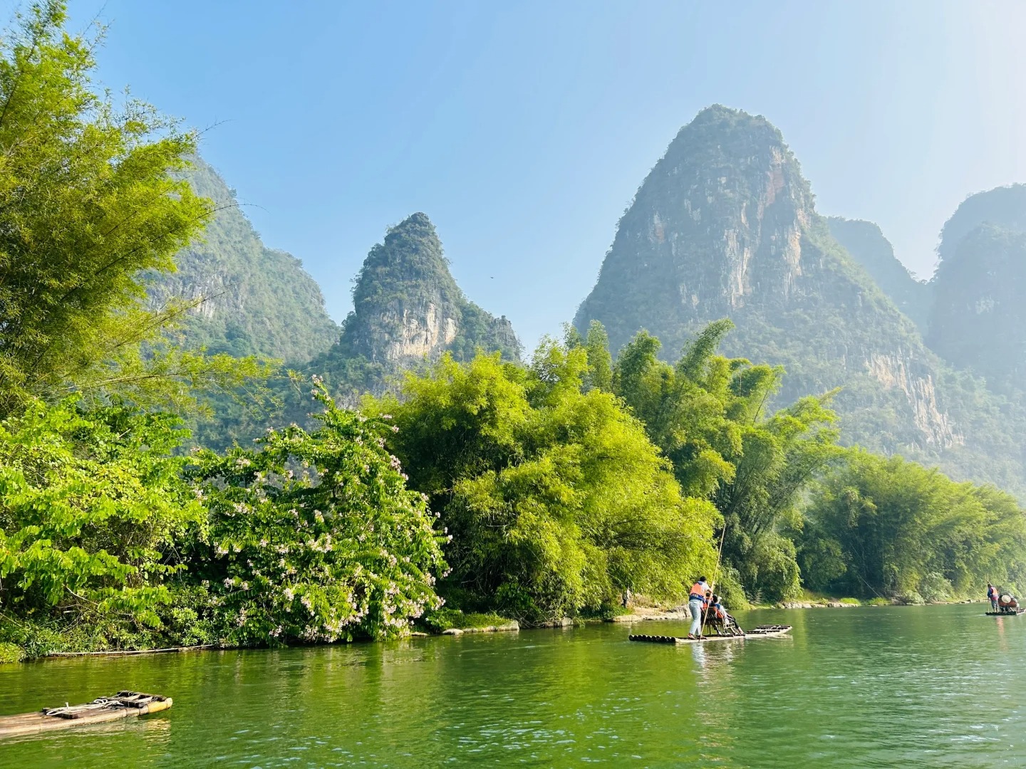 Du khách ngồi trên bè tre ngắm núi non.