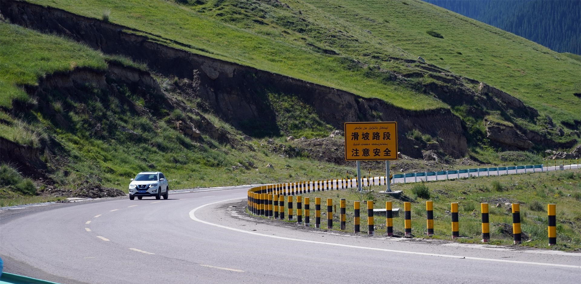 Một chiếc xe chạy băng qua cầu Guozigou giữa khung cảnh thảo nguyên bao la.