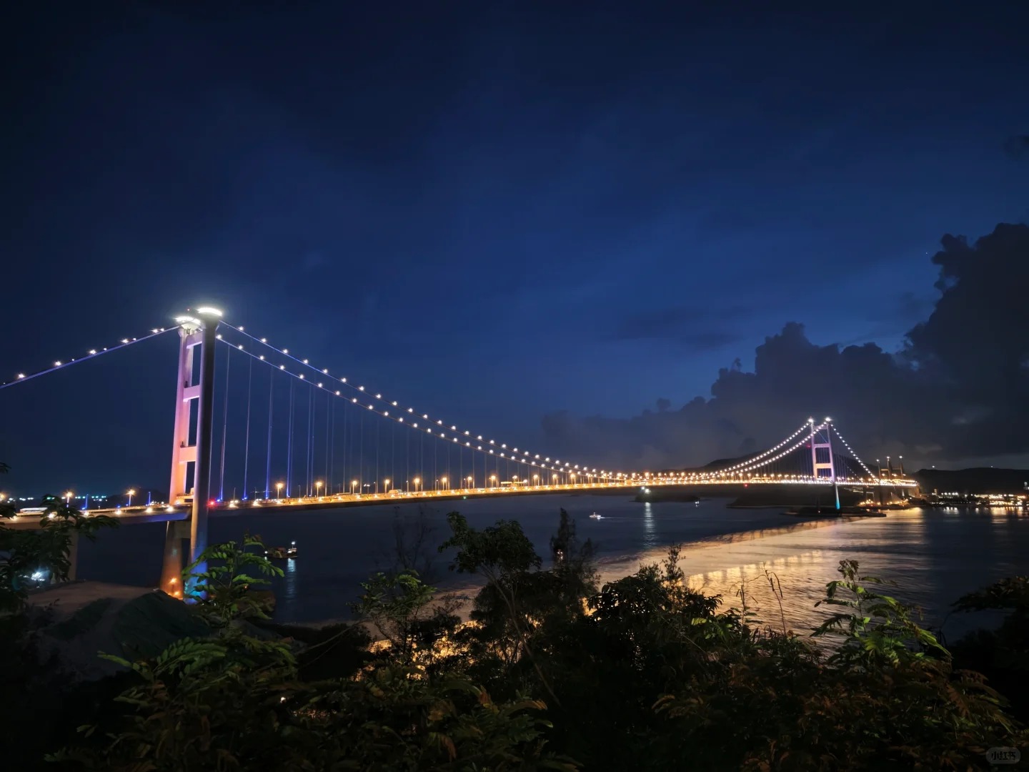 Đèn vàng lung linh phản chiếu xuống biển về đêm.