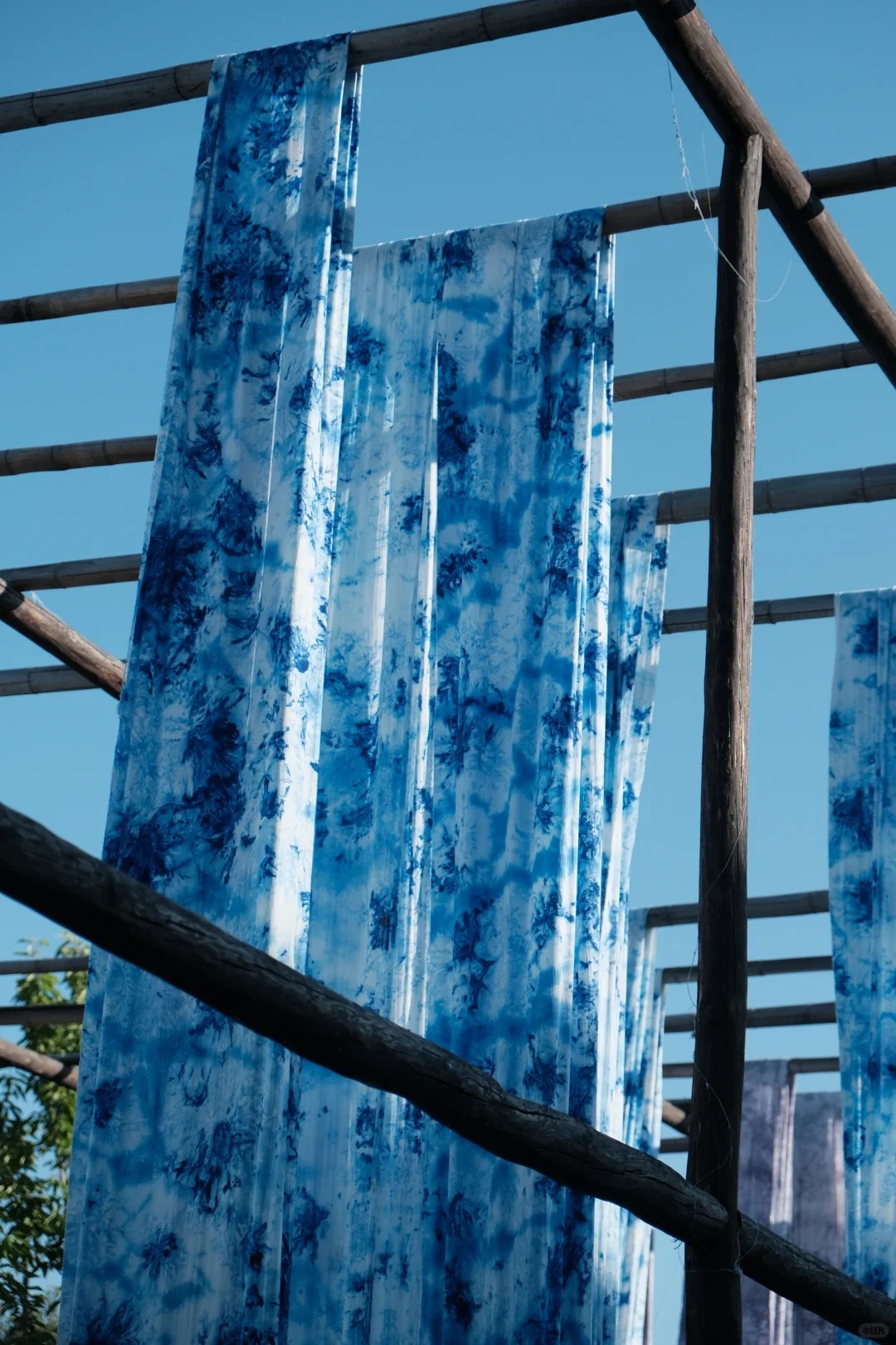 Du khách xem nghệ nhân nhuộm vải thủ công tại Yongshun, khung dệt và chậu nhuộm đặt giữa sân nhà cổ