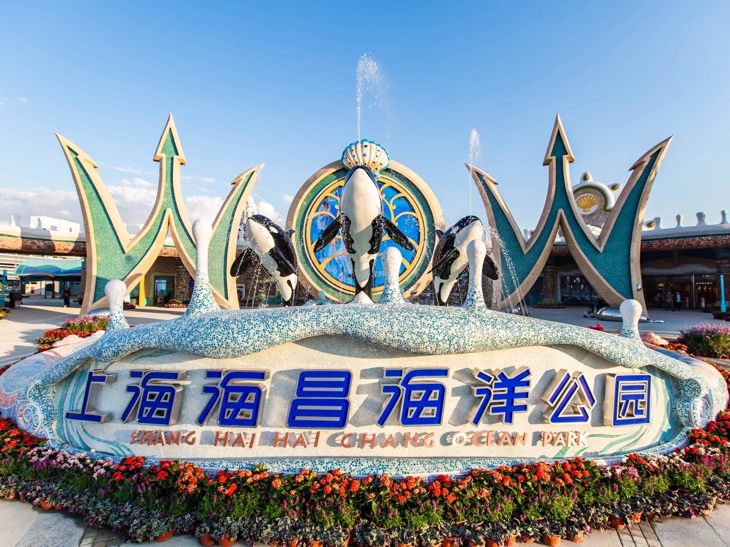 Cổng vào Haichang Ocean Park với biểu tượng cá voi khổng lồ và đài phun nước rực rỡ.