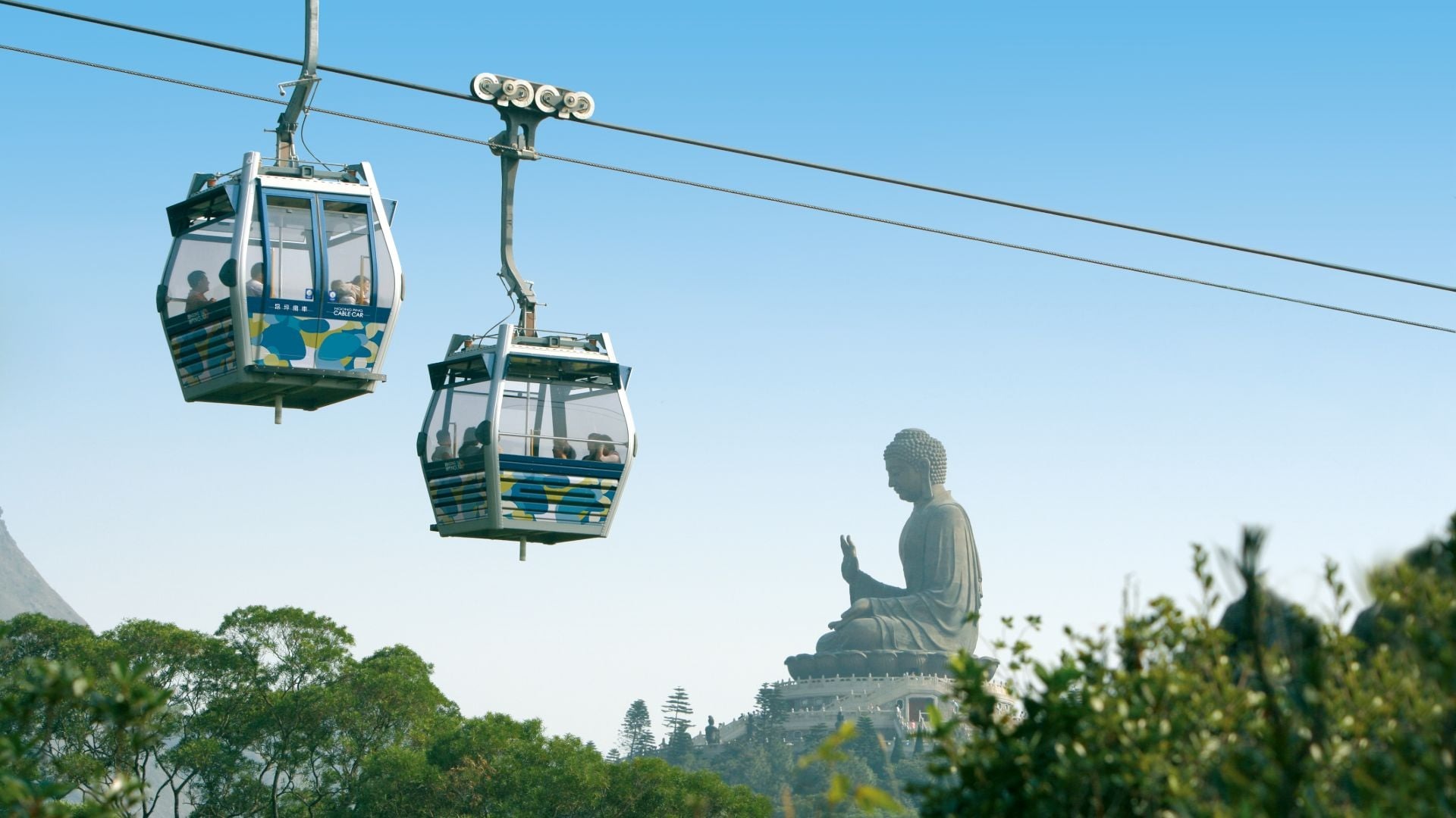 Du khách đi cáp treo Ngong Ping 360 ngắm cảnh núi vượt ngang qua biển