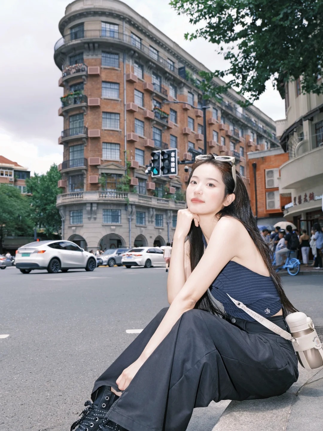 Du khách tạo dáng bên tường gạch đỏ, phía sau là Wukang Mansion.