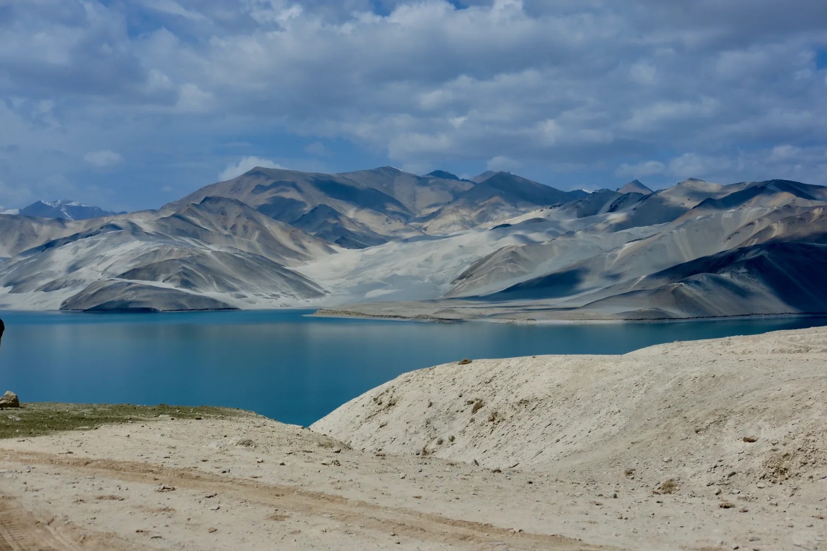 Bờ cát trắng mịn ôm lấy hồ nước trong veo, tạo khung cảnh tương phản độc đáo