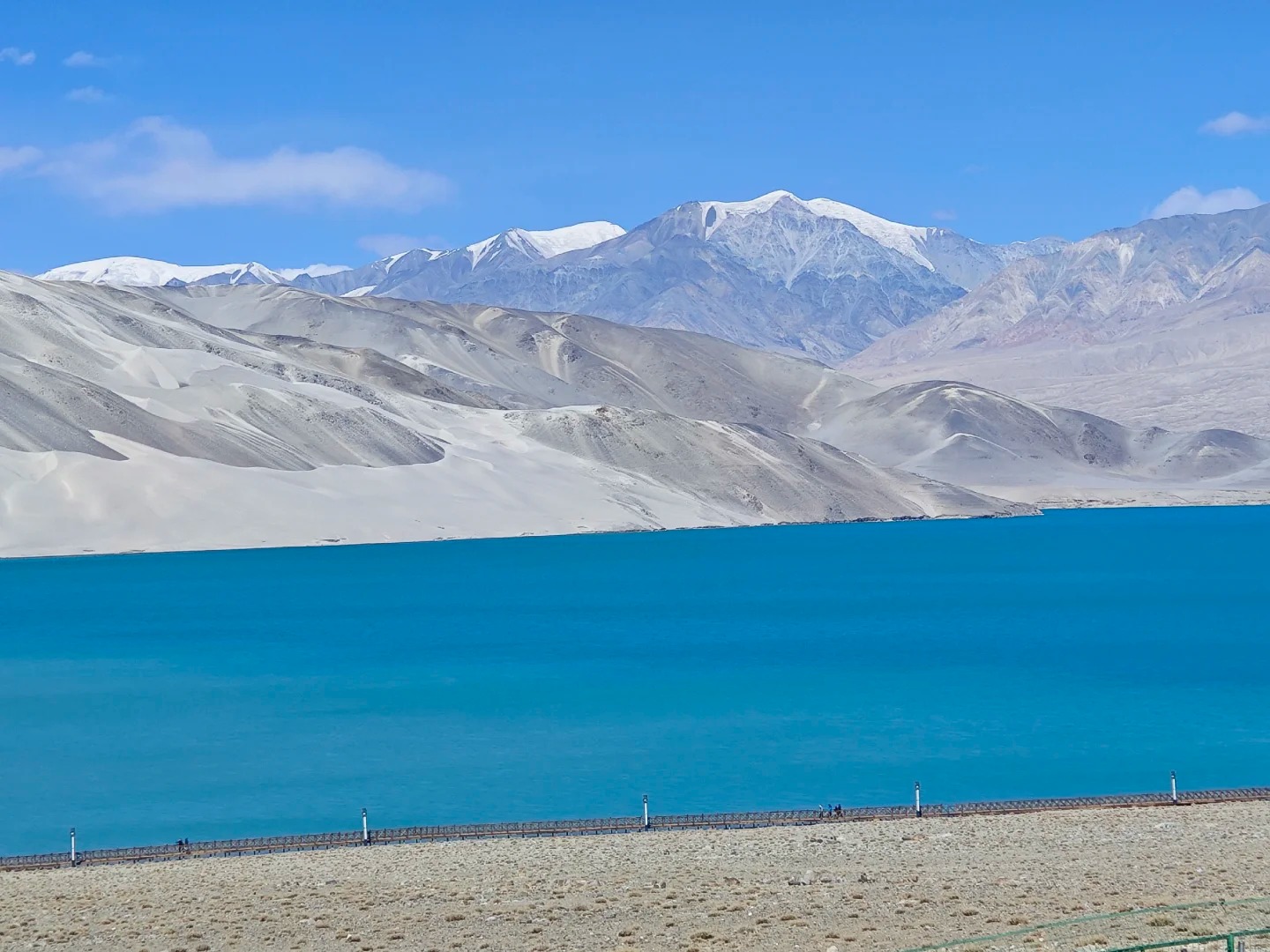 Mặt nước hồ Baisha phẳng lặng như gương, soi bóng núi tuyết phía xa