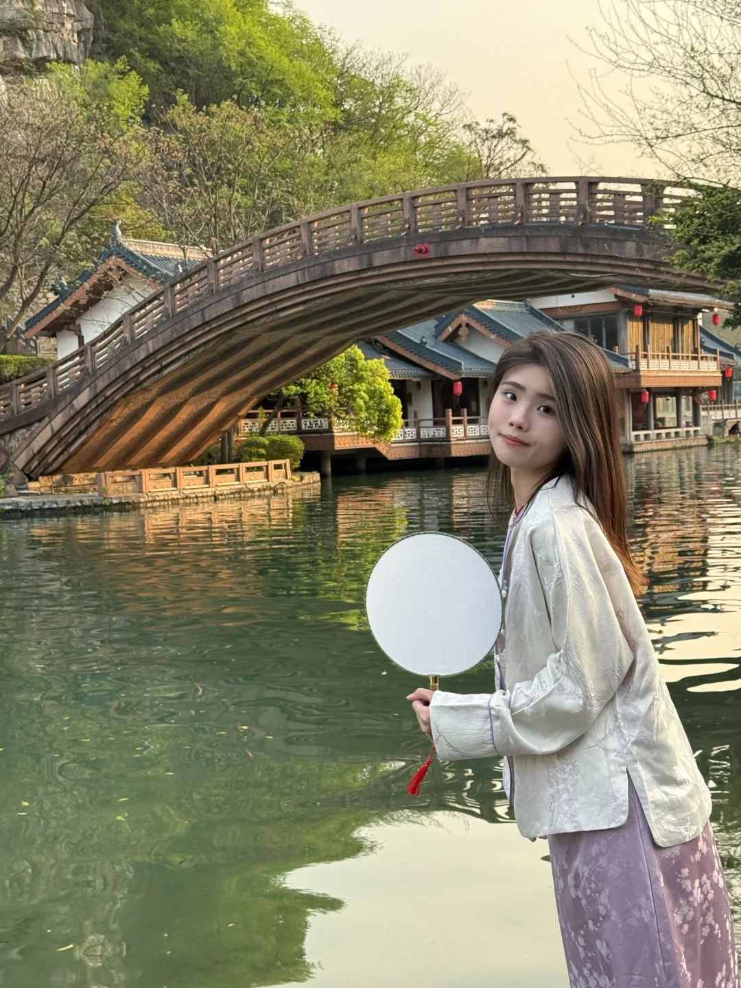 Du khách chụp ảnh check-in bên cầu đá tại Hồ Mộc Long.