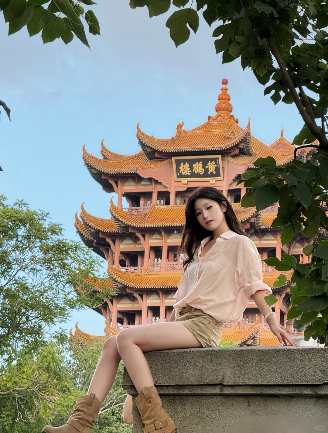 Du khách chụp ảnh check-inphía sau xa xa là Hoàng Hạc Lâu.