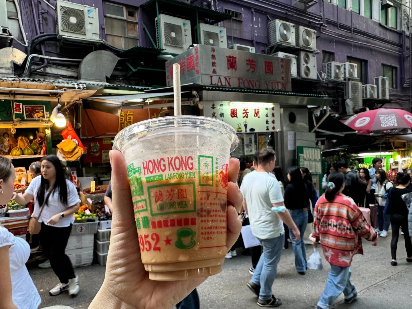 Du kh&aacute;ch tour HanVina Travel check-in cầm ly tr&agrave; sữa tất lụa trước quầy sắt xanh Lan Fong Yuen