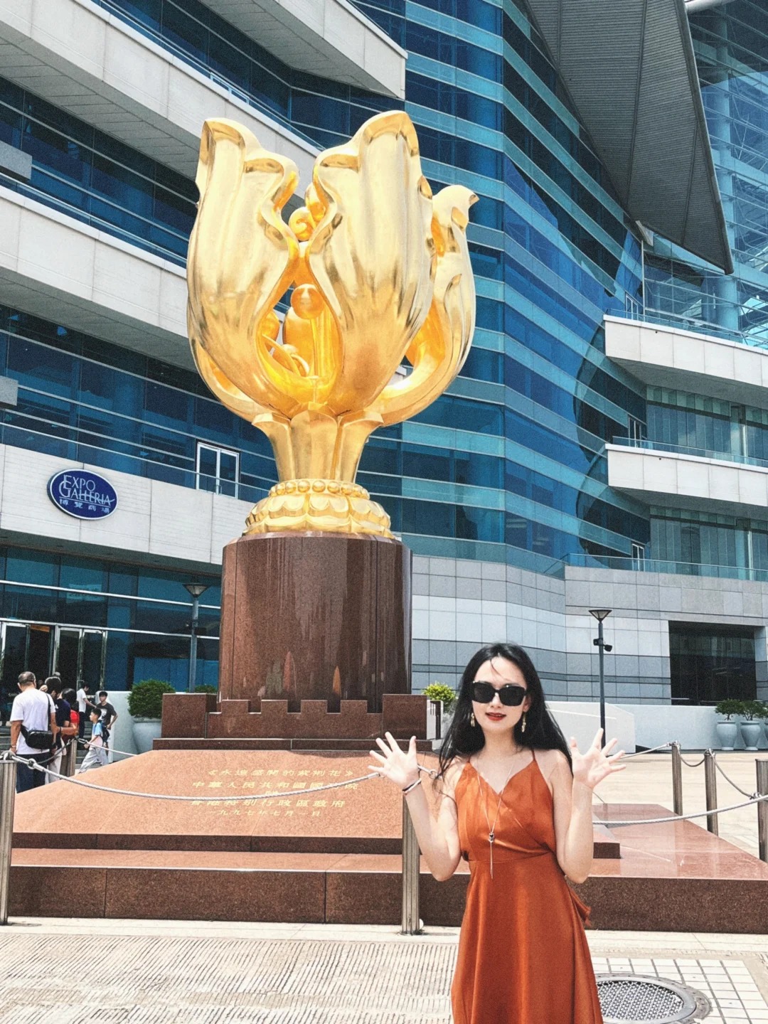 Du kh&aacute;ch chụp ảnh check-in trước tượng hoa v&agrave;ng.