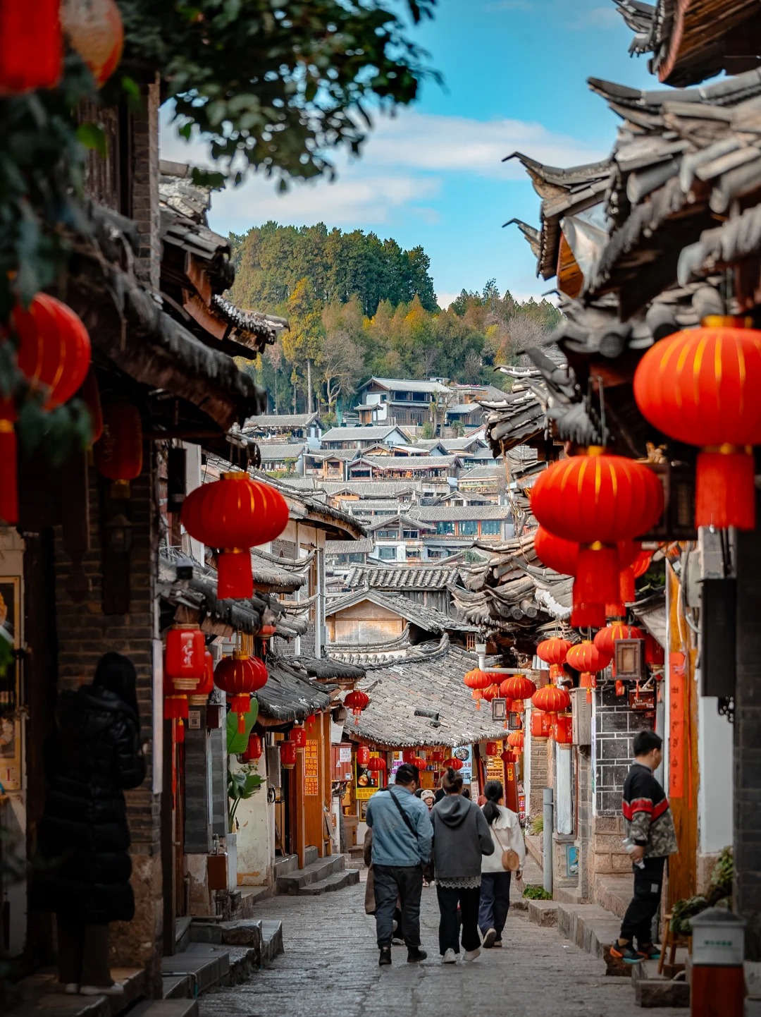 Du khách dạo bộ trên con đường lát đá cổ xưa tại Thành Cổ Lệ Giang, tận hưởng không gian hoài niệm.