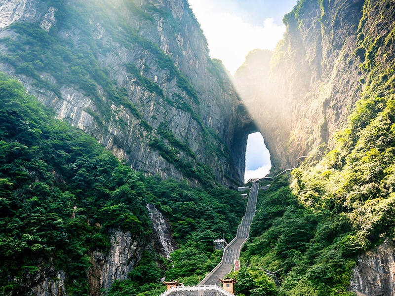 Cổng trời Thiên Môn Sơn nhìn từ xa, vòm đá khổng lồ xuyên qua núi, nổi bật giữa biển mây trắng xóa.